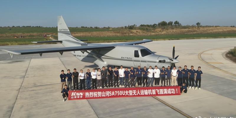The image captures a group of engineers and technicians standing proudly in front of the SA750U cargo drone, which represents a significant milestone in China's drone industry. The large, unmanned aerial vehicle, designed for heavy cargo transport, is shown on a runway, highlighting its impressive size and capabilities. The banner held by the team celebrates the successful test flight of this advanced drone, underscoring China's ambitious efforts to lead in the field of aerial logistics and innovative transport solutions. The setting emphasizes both the scale of the project and the teamwork behind this technological achievement